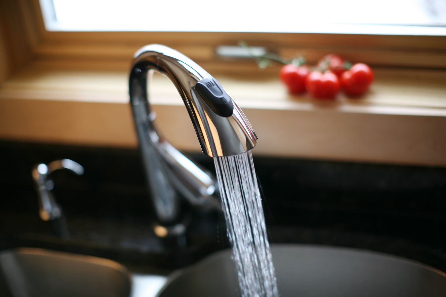 A kitchen faucet running with what might be Filtered water